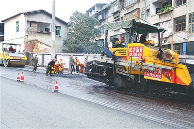 在政和县北大路施工现场，工人们正在完成最后几米的“白改黑”。（曾大龙 摄）